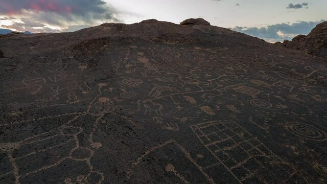Time lapse tracking shot of sunset sky over Native American rock art panel in California