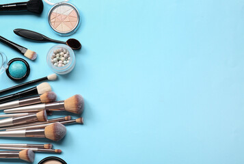 Set of makeup brushes and cosmetics on color background