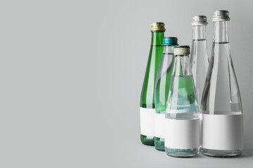 Bottles of clean water on light background