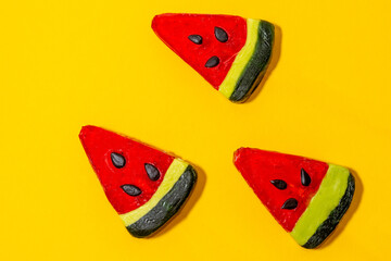 Three cute colorful lollipops look like a watermelon on a yellow background