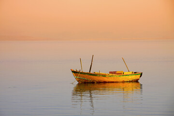 Fototapeta premium empty orange boat used by local fishermen living near lake Qaroun in El Fayoum south of Cairo. 