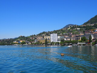Fototapeta na wymiar MONTREUX, SWITZERLAND on JULY 2017: Scenic townscape of Lake Geneva and european city in canton Vaud, clear blue sky in warm sunny summer day.