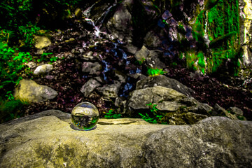 a view of a waterfall through a glass sphere