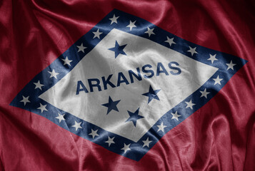 waving shining big flag of arkansas state on a silky texture