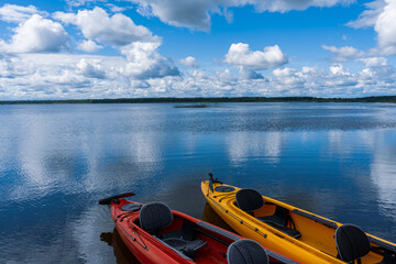 Obraz premium Red and yellow kayaks on the blue water of the lake