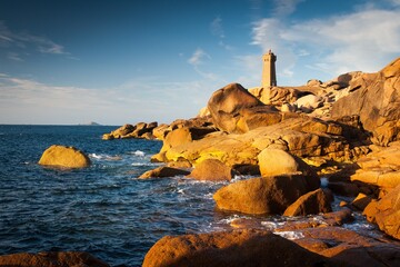 Lighthouse in France Brittany. Rocky sea coast with nice autumn colors.