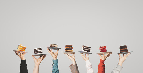 Many plates with pieces of different cakes in the hands of the waiters who lifted them up. A place for your text