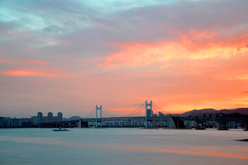 Fototapeta premium Dongbaek island and Gwangandaegyo bridge during colorful sunset in Busan city, South Korea
