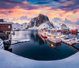 Sunrise on Hamnoy port with Festhaeltinden mount on background, Norway, Europe. Frosty morning scene of Lofoten Islands. Snowy winter seascape of Norwegian sea. Calm outdoor scene over polar circle. © Andrew Mayovskyy