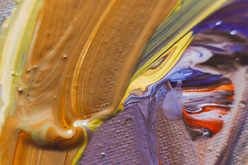 selective focus: Fresh colored oil paints on a woven canvas are abstractly mixed and closely...