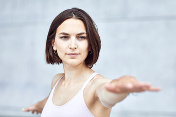 Frau/M&auml;dchen in Pastell gekleidet macht Outdoor Yoga &Uuml;bungen/Sonnegru&szlig; in moderner Beton Architektur. Urbanes Leben. 
