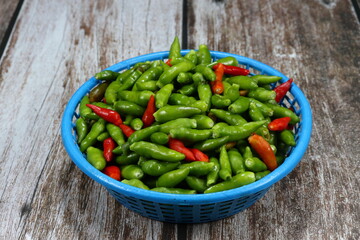 Pile of fresh and organic chilly on the plastic basket. Famous hot and spicy ingredients in Asia restaurant. 