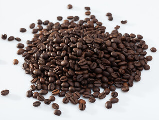Pile of aromatic roasted coffee beans on white surface..