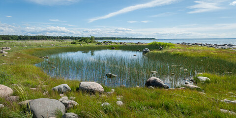 Fototapeta na wymiar Wild rocky coastline of the Baltic sea and small lake in summer. The Gulf of Finland, Estonia.