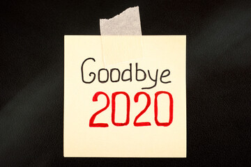 Note with words Goodbye 2020 attaches on black board.