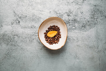 Autumn concept with coffee beans and yellow leaf on concrete background with copy space