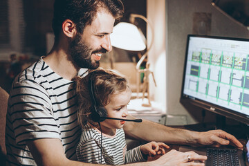 Father and daughter are working on a laptop. businessman working from home and watching the child....