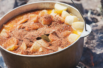 Spicy soup with vegetables boiling in a cauldron