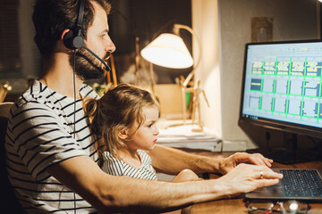 Stylish Bearded father working at home while babysitting his playful daughter