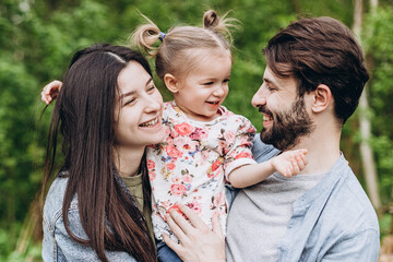 Happy stylish family: Photo of a young family enjoying a vacation in a park in a spring countryside