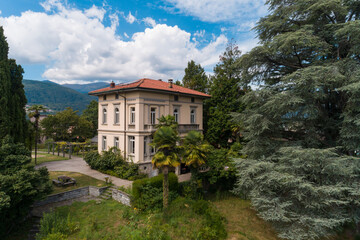 Fototapeta na wymiar Ancient villa surrounded by nature in the hills in Switzerland. Sunny summer day