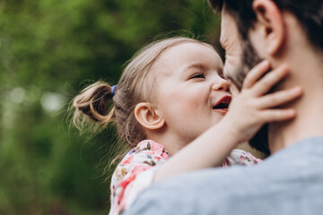 happy couple of father and his young daughter having fun in the park on a walk together