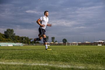 Full length of soccer player in shape running on the field. © Dusan Petkovic
