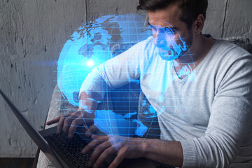 A serious caucasian manager in casual wears, using laptop to develop a new worldwide supply chain. Double exposure. globe and map hologram.