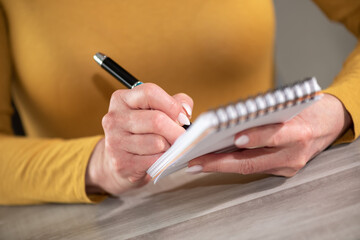 Female hands writing on notepad