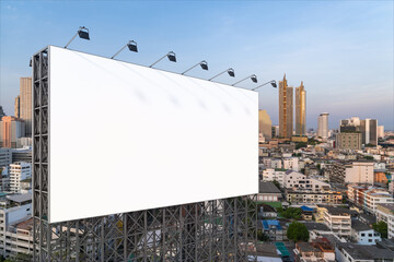 Blank white road billboard with Bangkok cityscape background at sunset. Street advertising poster, mock up, 3D rendering. Side view. The concept of marketing communication to promote or sell idea.