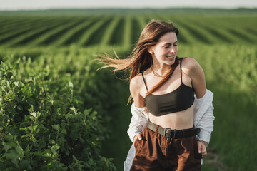 Young Adult Girl in White Shirt and Brown Shorts Having Fun in the Green Currant Fields