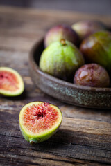 Fresh ripe figs in a bowl closeup on dark background, rustic style