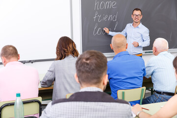Obraz premium Adult lecturer talking to mixed age students during seminar