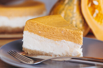 Pumpkin pie, tart made for Thanksgiving day on plate. Table in cozy cafe background