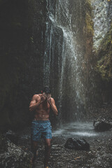 young man in a waterfall