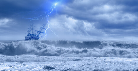 Sailing old ship in storm sea on the background heavy clouds with lightning