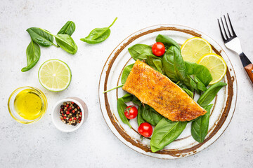 Grilled Spiced Salmon with fresh Spinach and Tomatoes Salad and Lemon Slices, top view