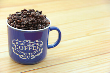 natural black coffee beans in a blue mug