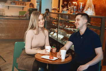 Two casual students having a cup of coffee in college canteen