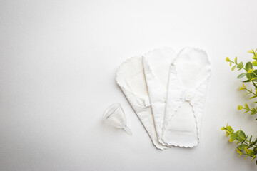 Different types of feminine hygiene products-menstrual cups, sanitary reusable pads on white background. Zero waste concept of menstruation.