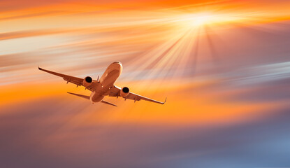 White passenger airplane in the clouds at amazing sunset - Travel by air transport
