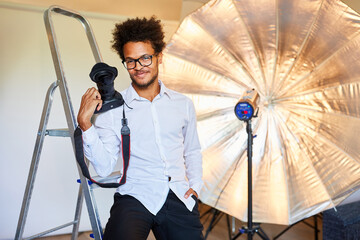 Kreativer Fotograf mit Kamera im Fotostudio