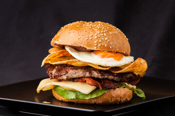 hamburger on black plate isolated black background