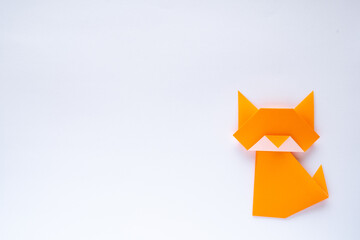 orange origami cat on white background