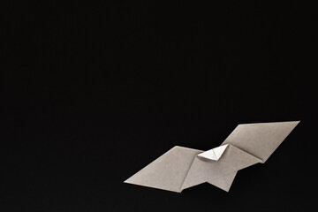 gray origami bat on black background