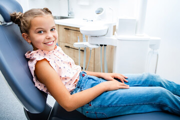 Child smiling while sitting in the dentist's chair. Kid teeth treatment