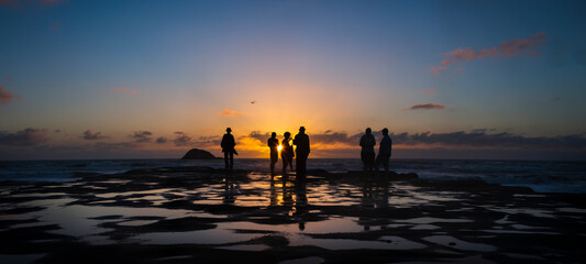 Fototapeta na wymiar Silhouette image of people enjoying sunset at Muriwai beach, Waitakere, Auckland