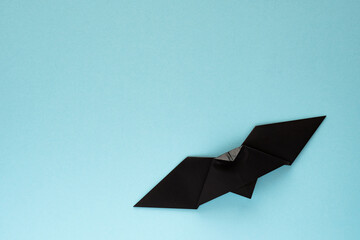 black origami bat on sky blue background