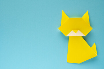 yellow origami cat on sky blue background