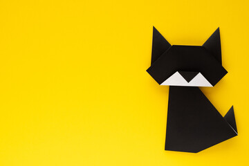 black origami cat on yellow background